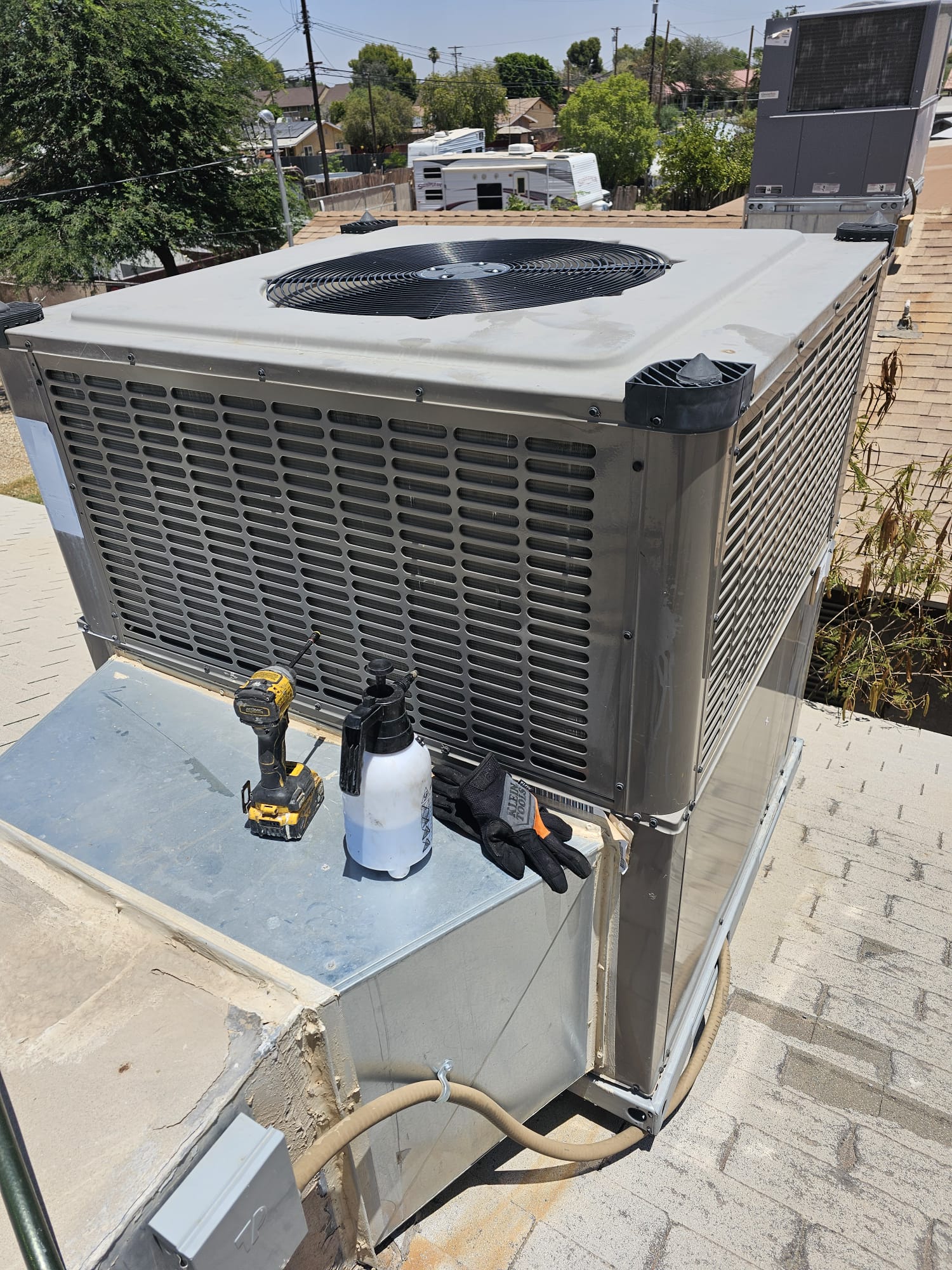 Unidad de aire acondicionado instalada en una azotea con herramientas de servicio