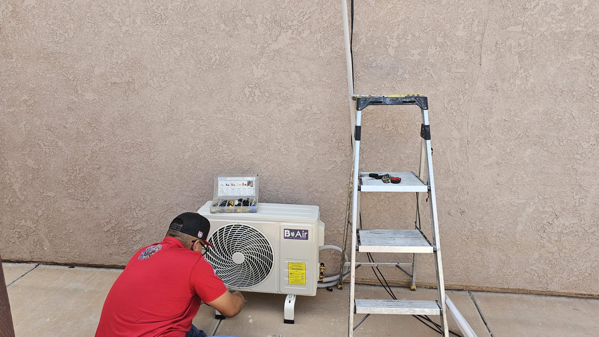 Técnico instalando una unidad condensadora exterior