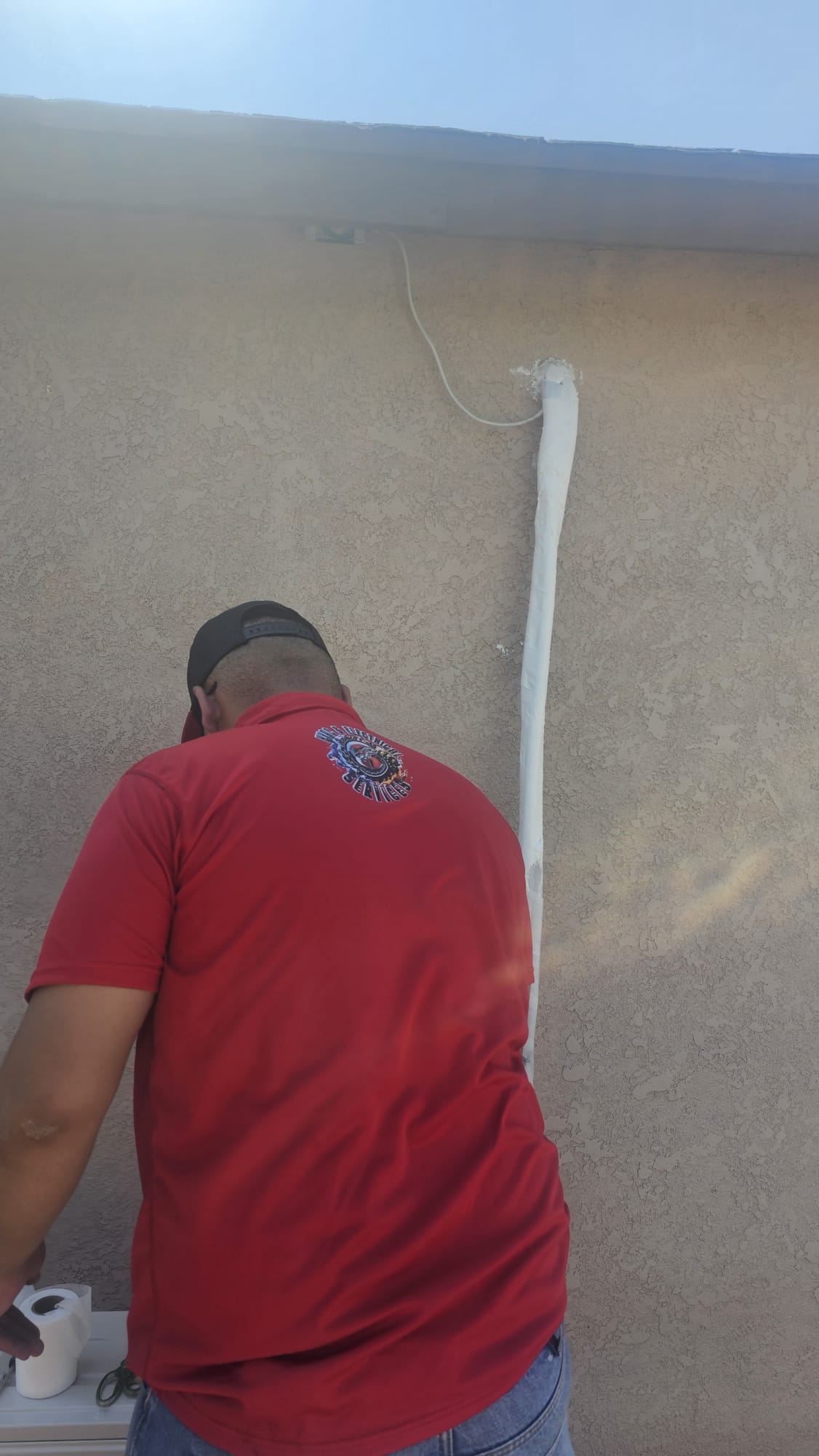 Técnico trabajando en la canalización de una instalación exterior